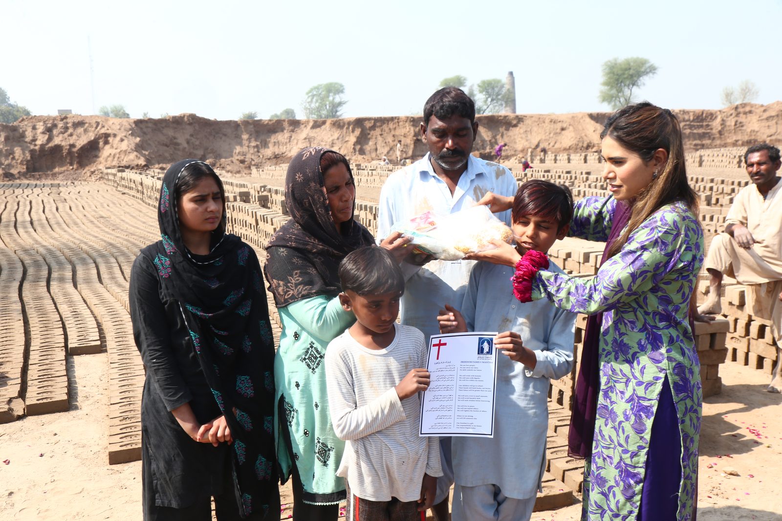 A family receiving their Freedom Family document and supplies at the brick kiln