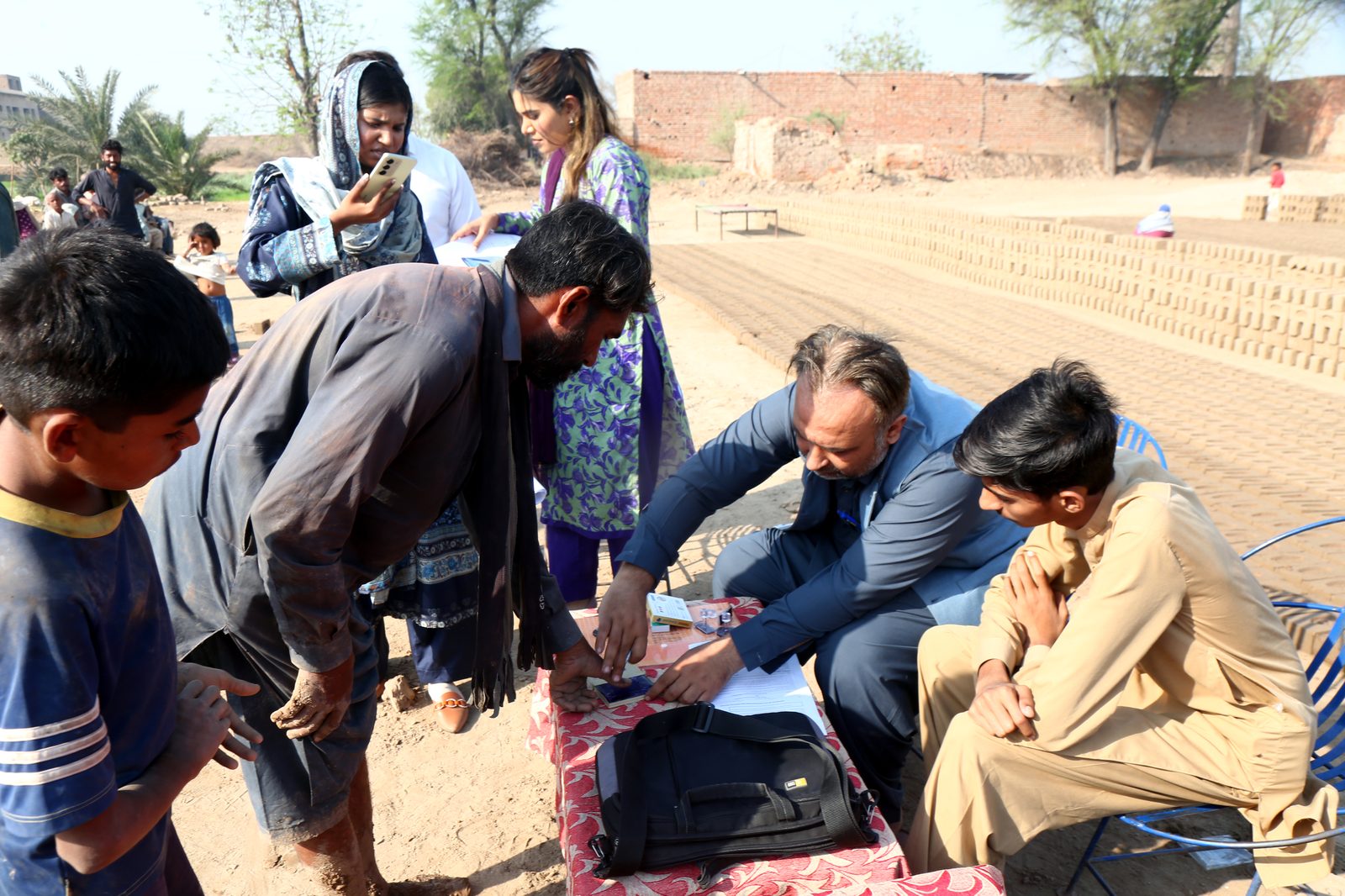 A worker pressing his thumbprint onto the settlement agreement