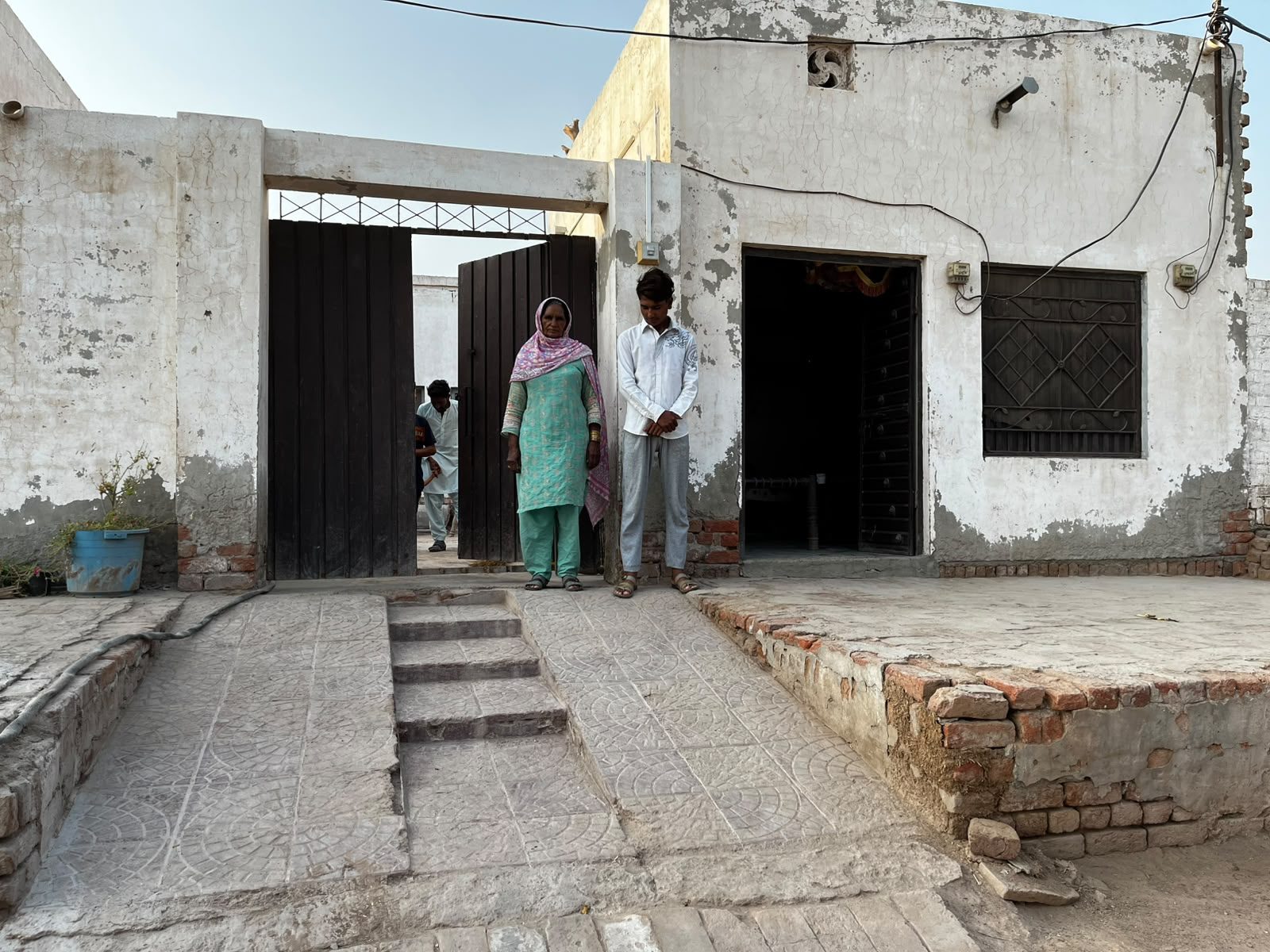 Kashif and his family standing outside their home