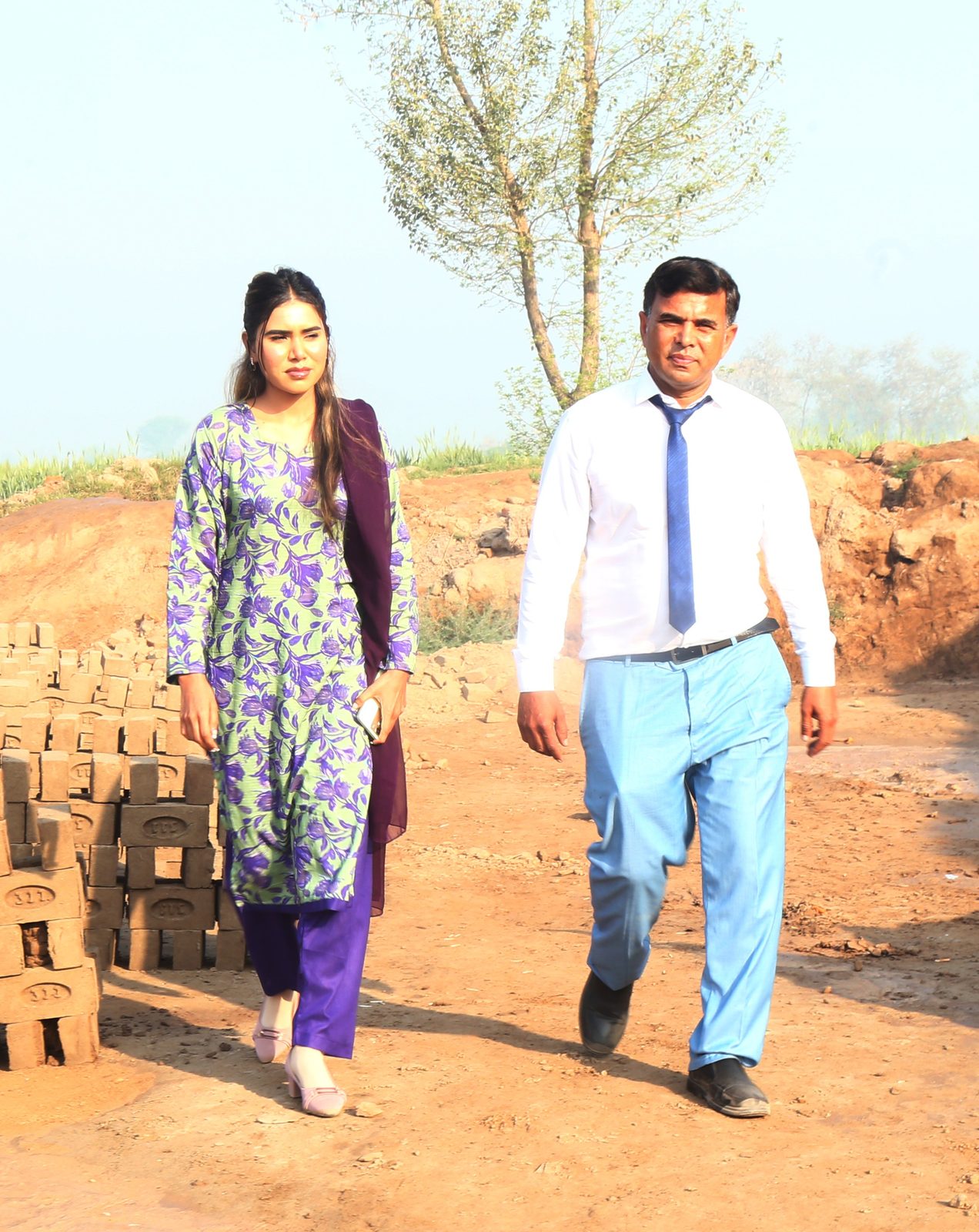 Mahnoor and Pastor Shahid Naveed walking together at the brick kiln