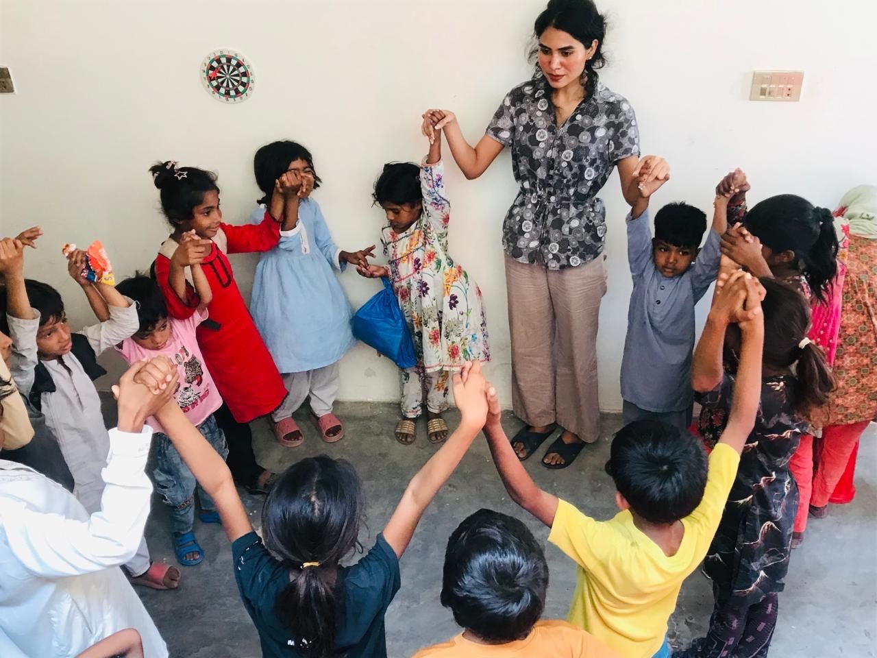 Mahnoor playing a circle game with children at the school