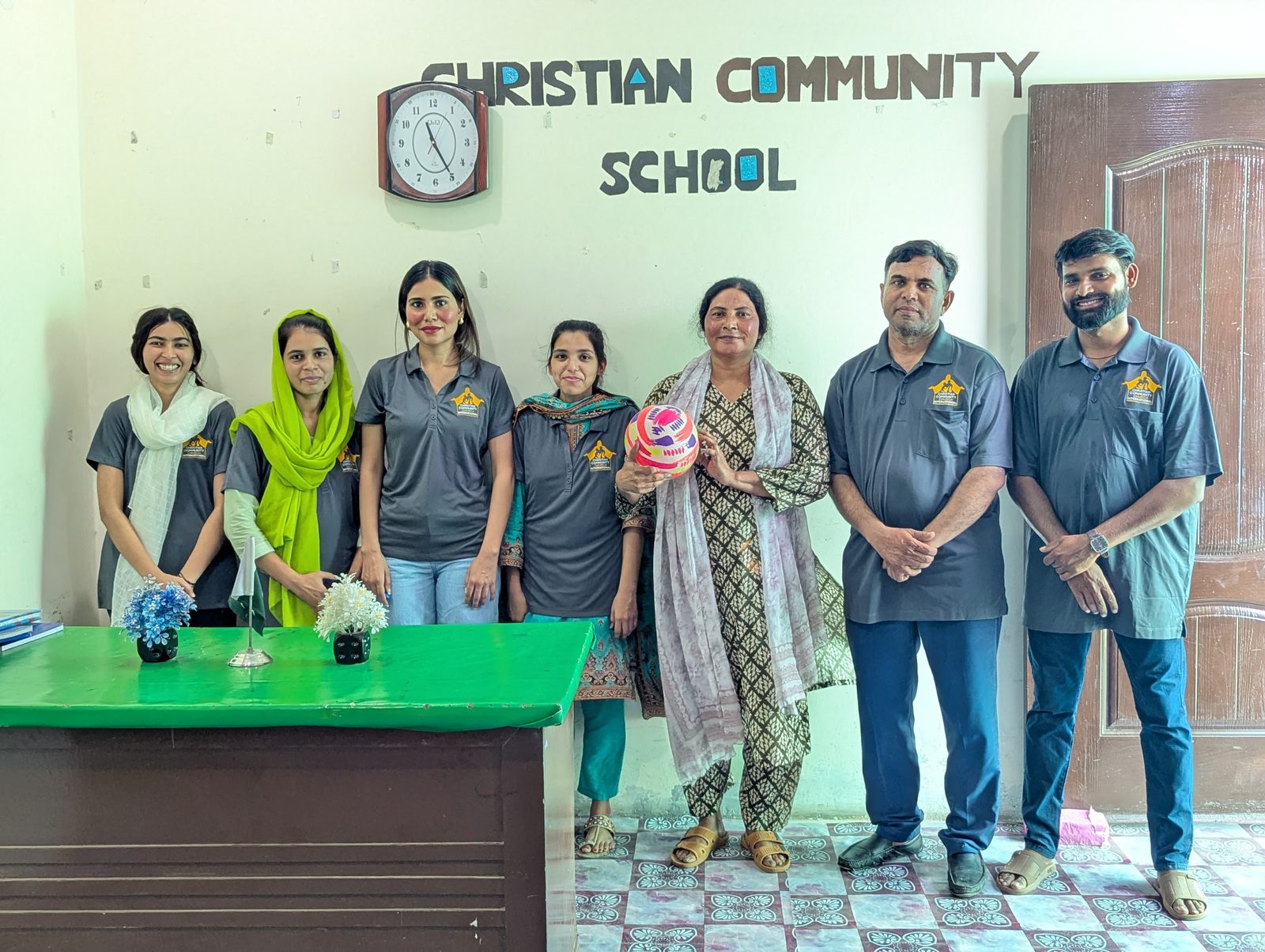 Christian Community School staff standing together inside the school