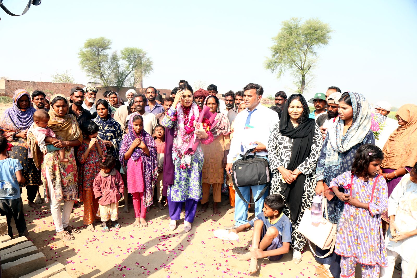 Mahnoor and team members with a crowd of families gathered at the kiln
