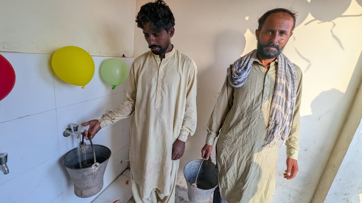Two men filling buckets with clean water from the new taps